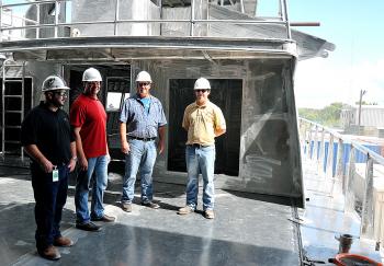Rodi Marine representatives examine the first of two 175-foot fast supply vessels that Swiftships is building for the Lafayette company. This one is expected to be completed in April with a second ready for delivery in July. From left, are Zeke Randaza, Wade Guillory and Timmy Charpentier, all of Rodi Marine, along with Swiftships project manager Allen Crochet.
