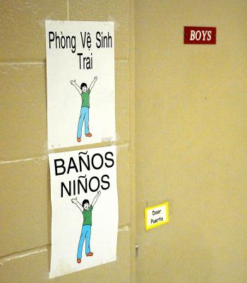 At J.S. Aucoin Elementary School in Amelia, the student population is so ethnically diverse that signs like these, indicating the boys’ bathroom, are often necessary in three languages. While 70 percent of the school’s students are either Hispanic or Vietnamese, 40 percent of those are identified as not yet being proficient in the English language.

