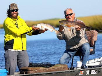 Book author Jake Bussolini, right, from North Carolina with his Grosse Savanne Guide and a red fish the angler caught during a media saltwater fishing trip at the Southeastern Outdoor Press Association annual conference in Lake Charles last weekend.
