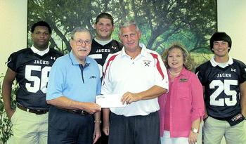 M C Bank made a donation to Patterson High School for their football scoreboard upgrade. Accepting the donation from M C Bank Executive Vice President Gerald Listi are Tommy Minton, Patterson head football coach and athletics director, and senior football players. From left are Kevin Merritt, Listi, Landon Thomas, Minton, Frances Dupre, M C Bank Human Resources/Marketing Officer; and Rene Maillet.
